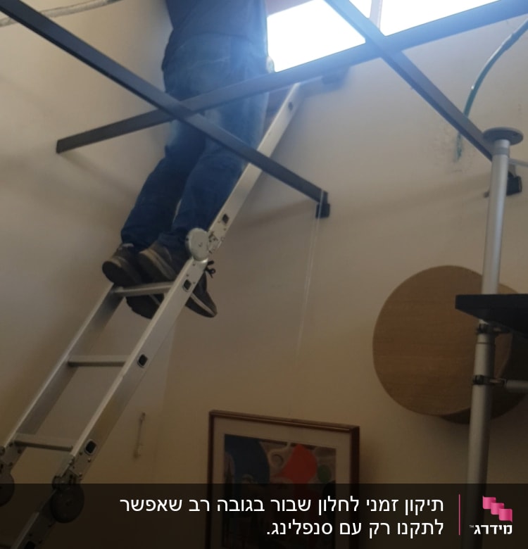 אדם על סולם ליד חלון זכוכית